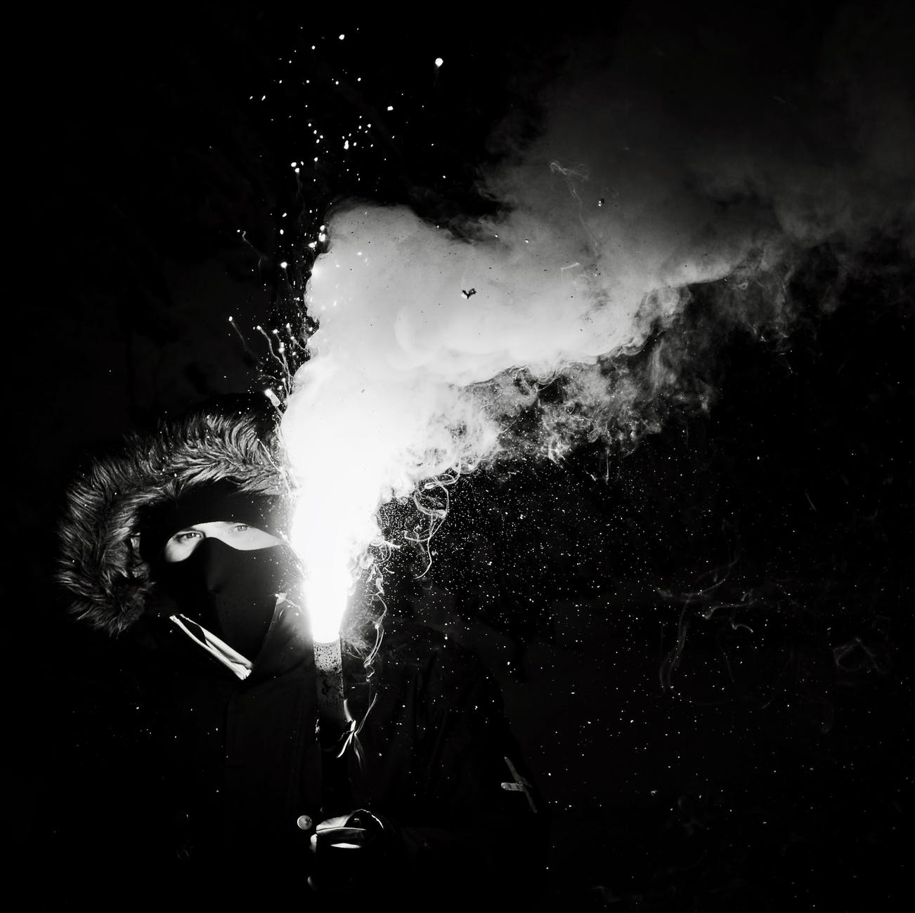 grayscale photography of person holding flare